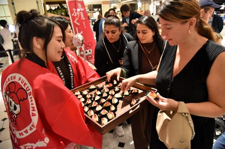 Customers sample peaches from Japan's Fukushima prefecture at Harrod's.